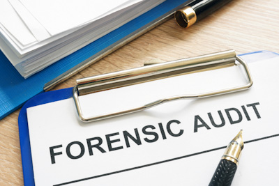 Forensic audit and financial documents on a desk.